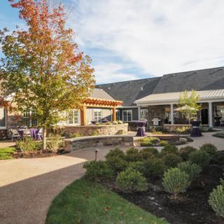 A landscaped garden with a pathway leading to a building under a clear sky.
