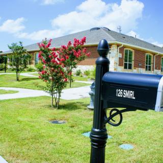 A suburban house with a mailbox surrounded by a landscaped garden.