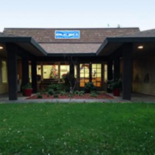 Entrance to a building with a visible sign and landscaped area.