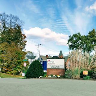 A scenic view of a building surrounded by trees and a clear blue sky.