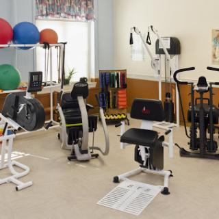 A well-equipped fitness area featuring various exercise machines and equipment for rehabilitation and strength training.