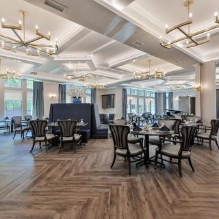 Elegant dining area with modern chandeliers and large windows.