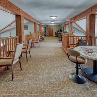 A cozy hallway with seating arrangements and wooden railings.