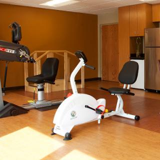 A well-equipped fitness space featuring a recumbent bike and other exercise machines.