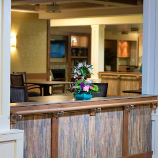 A welcoming lobby space featuring a decorative flower arrangement, comfortable seating, and warm lighting.