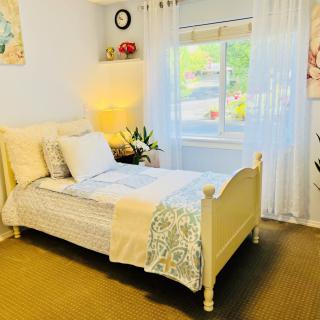 A cozy and bright bedroom featuring a single bed with elegant decor and a window letting in natural light.