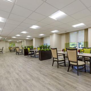 A modern dining area with neatly arranged tables and chairs, featuring contemporary decor and ample lighting.