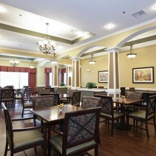 A spacious dining area with elegant furnishings and chandeliers.