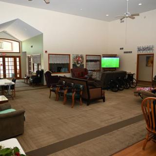 A spacious living room with comfortable seating, a television, and various furniture pieces in an open layout.