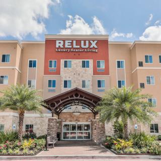 A modern hotel entrance with palm trees and a welcoming design.