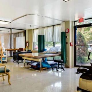 A spacious rehabilitation center with exercise equipment and treatment tables.