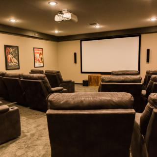A cozy home theater setup with comfortable recliners and a large projector screen.