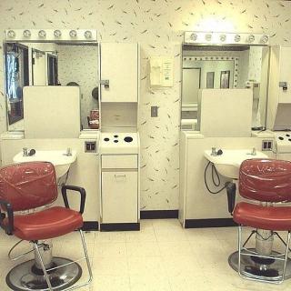 A vintage barbershop interior with red chairs, mirrors, and salon equipment.