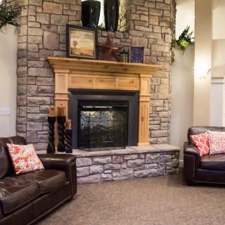 A cozy living room featuring a stone fireplace and comfortable leather sofas.