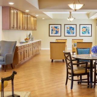 A cozy living room with comfortable seating, artwork on the walls, and warm lighting.