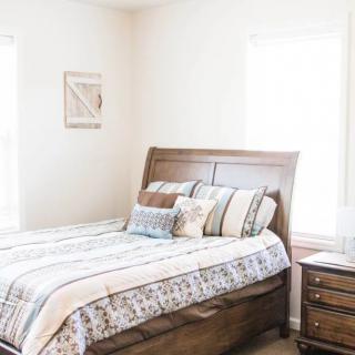 A cozy bedroom with a neatly made bed and wooden furniture.