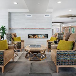 A modern living room with a central fireplace, surrounded by comfortable seating and stylish decor.
