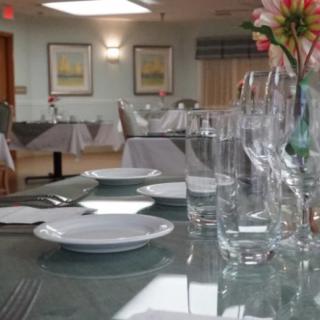 An elegantly set dining table in a restaurant, featuring neatly arranged plates and glasses.