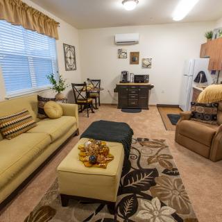 A cozy living room featuring a sofa, decorative carpet, and assorted furniture.