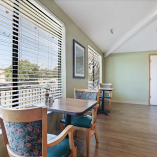 A cozy dining area with natural light filtering through the window blinds.