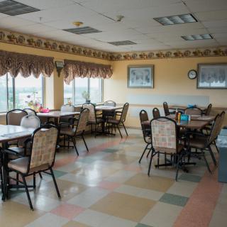 An empty dining room with several tables and chairs arranged neatly.