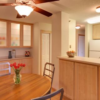 Cozy kitchen and dining area with wooden cabinets and a round table adorned with tulip flowers.