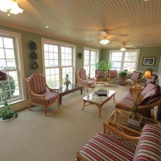 A well-lit living room with comfortable seating and large windows.
