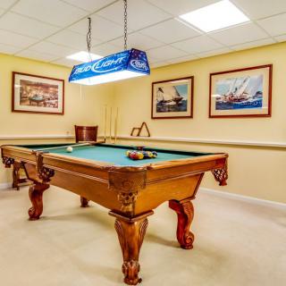 A billiard room featuring a pool table, wall artwork, and overhead lighting.