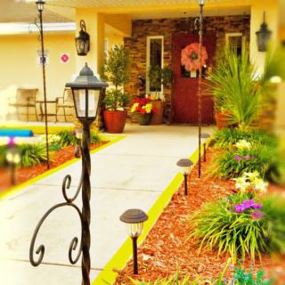 A colorful and inviting front porch with lush landscaping and decorative lighting.
