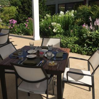 A beautifully set outdoor dining table on a garden patio.