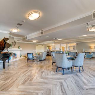 A spacious lounge with elegant seating, a piano, and a fireplace.