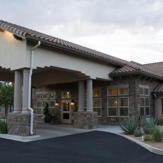 A modern building with a covered entrance and stone facade.