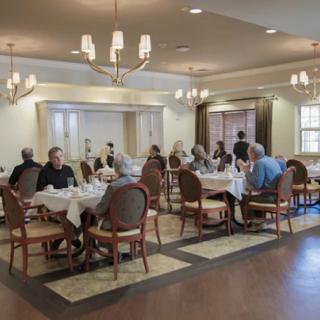 Seniors enjoying a meal together in an elegantly decorated dining room.