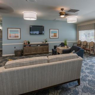 A cozy living room with comfortable seating, modern lighting fixtures, and a wall-mounted television.