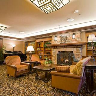 A cozy living room with a fireplace, comfortable seating, and warm lighting.