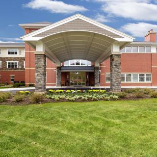 A modern building with a covered entrance and well-maintained landscaping.
