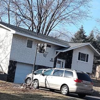 A suburban home with a minivan parked in the driveway.