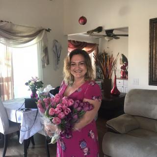 A woman holding a bouquet of flowers in a living room.