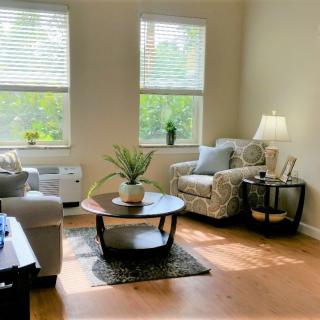 A cozy and bright living room with a sofa, armchair, and coffee table.