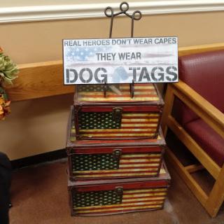 A decorative stand featuring a sign about dog tags, emphasizing their importance for service dogs.