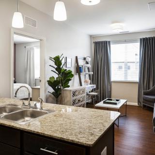 A modern open-concept kitchen and living room with granite countertops and stylish decor.