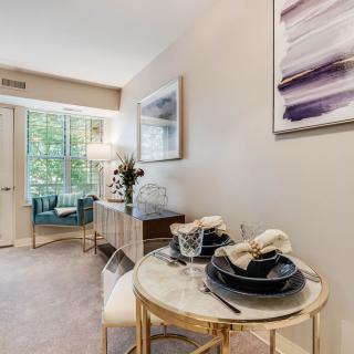 A modern living room with a dining area, featuring elegant decor and a stylish table setting.