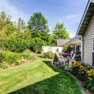 A well-maintained backyard garden with a patio and lush greenery.