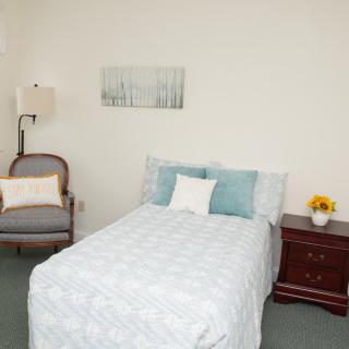 A minimalist bedroom with a single bed, nightstand, and simple decor.