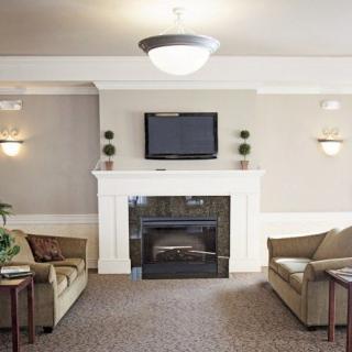 A modern living room with a cozy fireplace, two sofas, and a television mounted above the mantel.