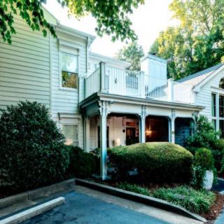 A residential house with a charming veranda and surrounding greenery.