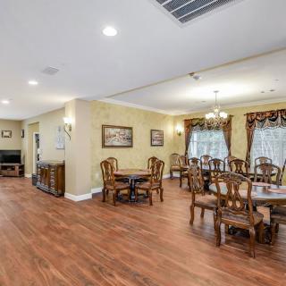 A spacious dining and living area featuring elegant wooden furniture and warm lighting.