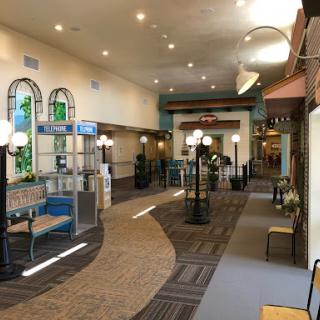 A well-lit indoor corridor featuring seating areas and decorative elements.