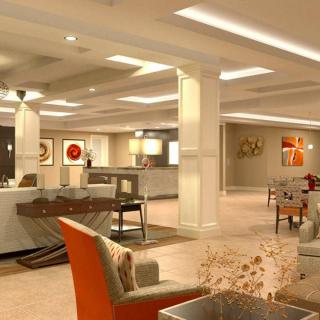 A modern and well-lit lobby area featuring comfortable seating and artwork on the walls.