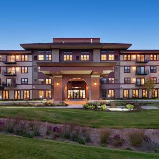 A modern residential building with well-maintained landscaping in the evening.